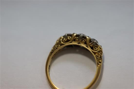 An Edwardian 18ct gold and graduated three stone diamond ring, size O.